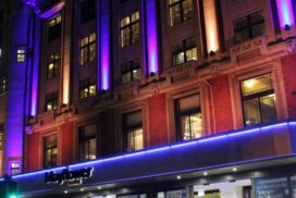 Exterior of Mayflower Theatre at night, illuminated with purple lights.