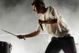 Dan Smith of Bastille hitting a drum on stage at Victorious Festival.