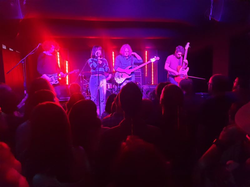 Just Mustard on stage at The Loft, bathed in red light.