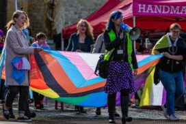 Transgender Pride march with large flag in front of the Bargate, Southampton.